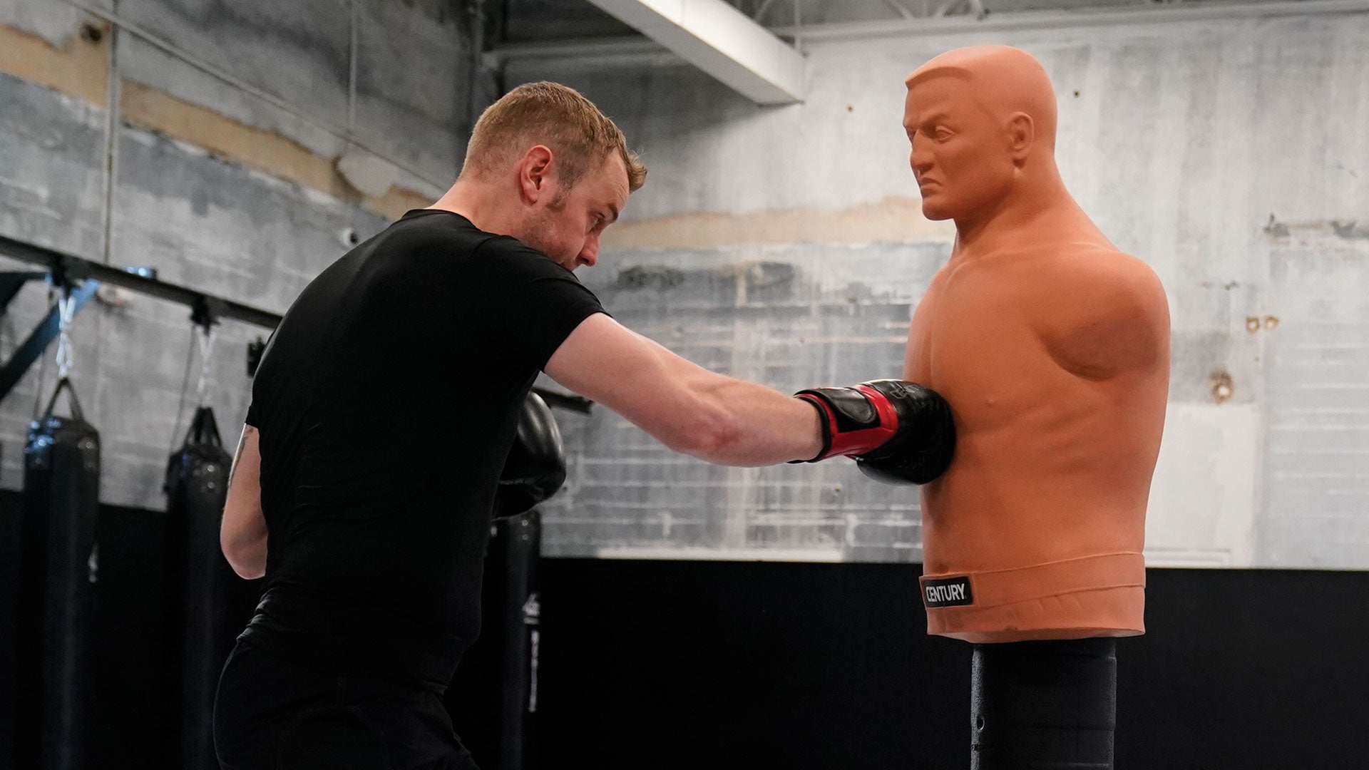 man punching bob on mat in gym